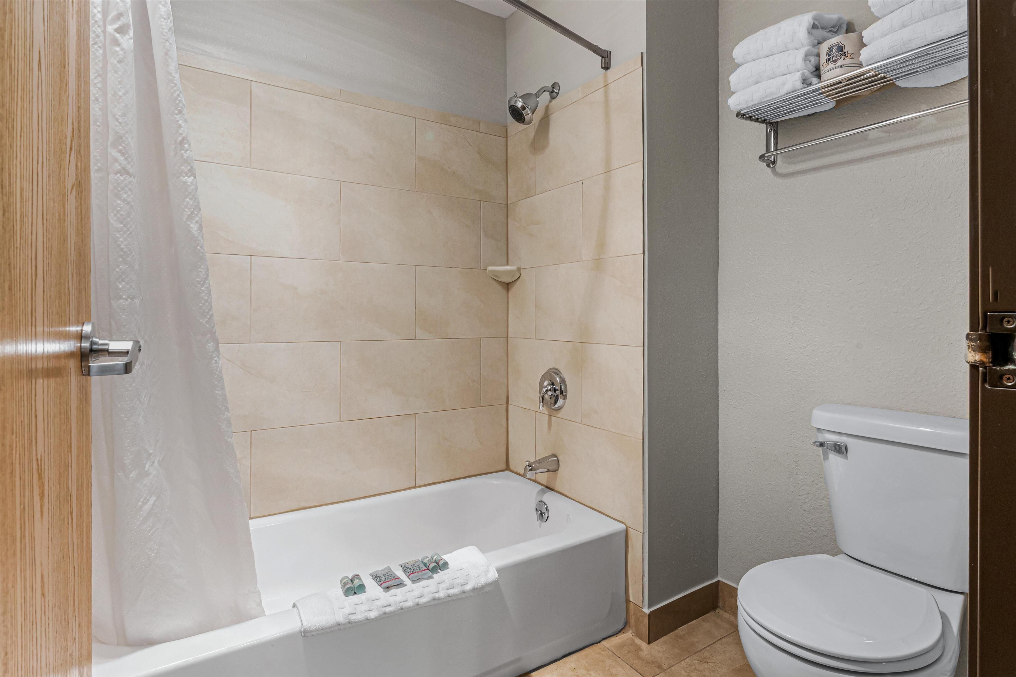 Un baño moderno con bañera, ducha e inodoro.