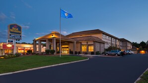 A Best Western hotel with a prominent sign, a flag, and a well-lit entrance. - Best Western Ambassador Inn & Suites (Wisconsin Dells)