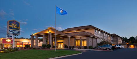 A Best Western hotel with a prominent sign, a flag, and a well-lit entrance.