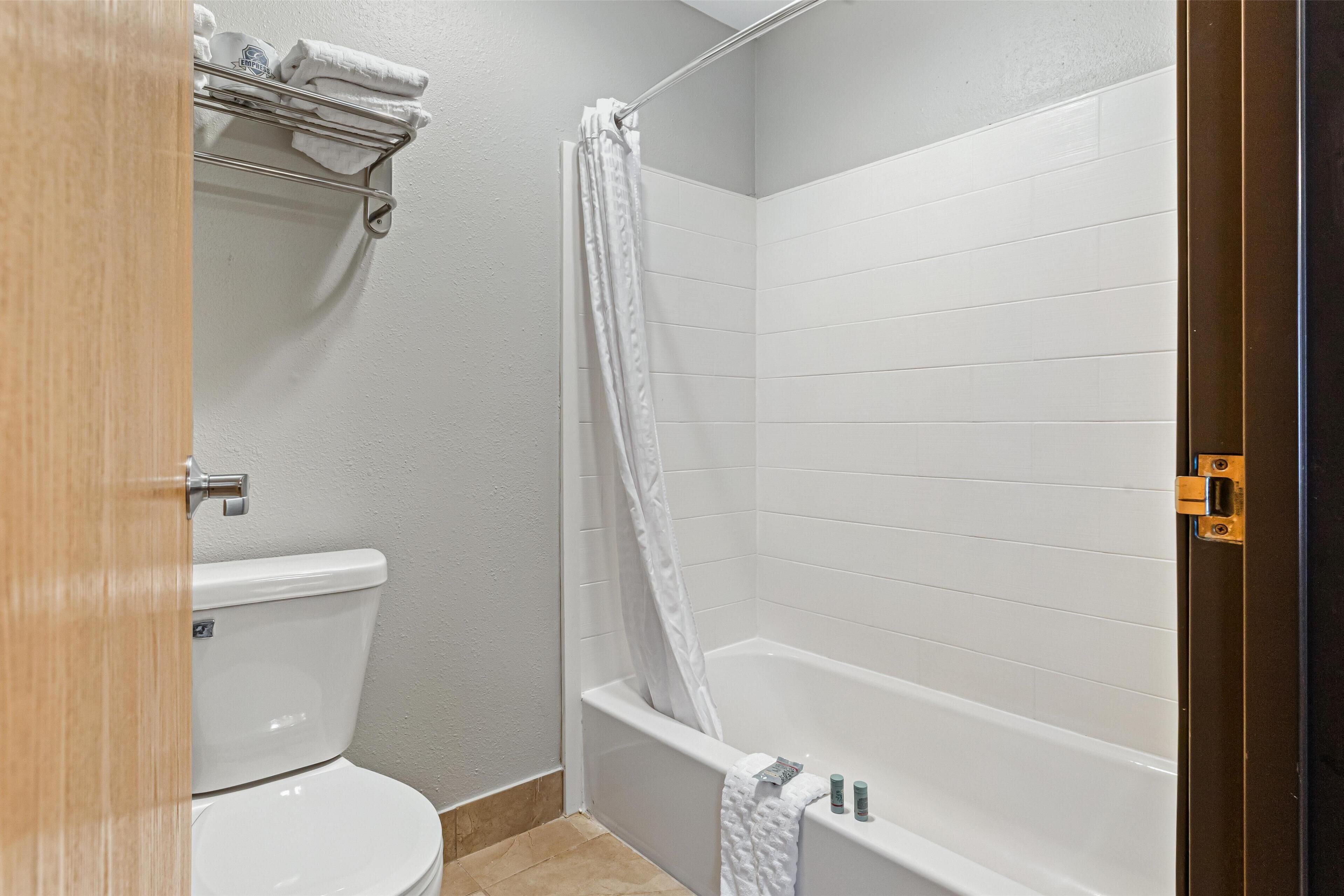 A bathroom with a toilet, a bathtub, and a shower curtain.