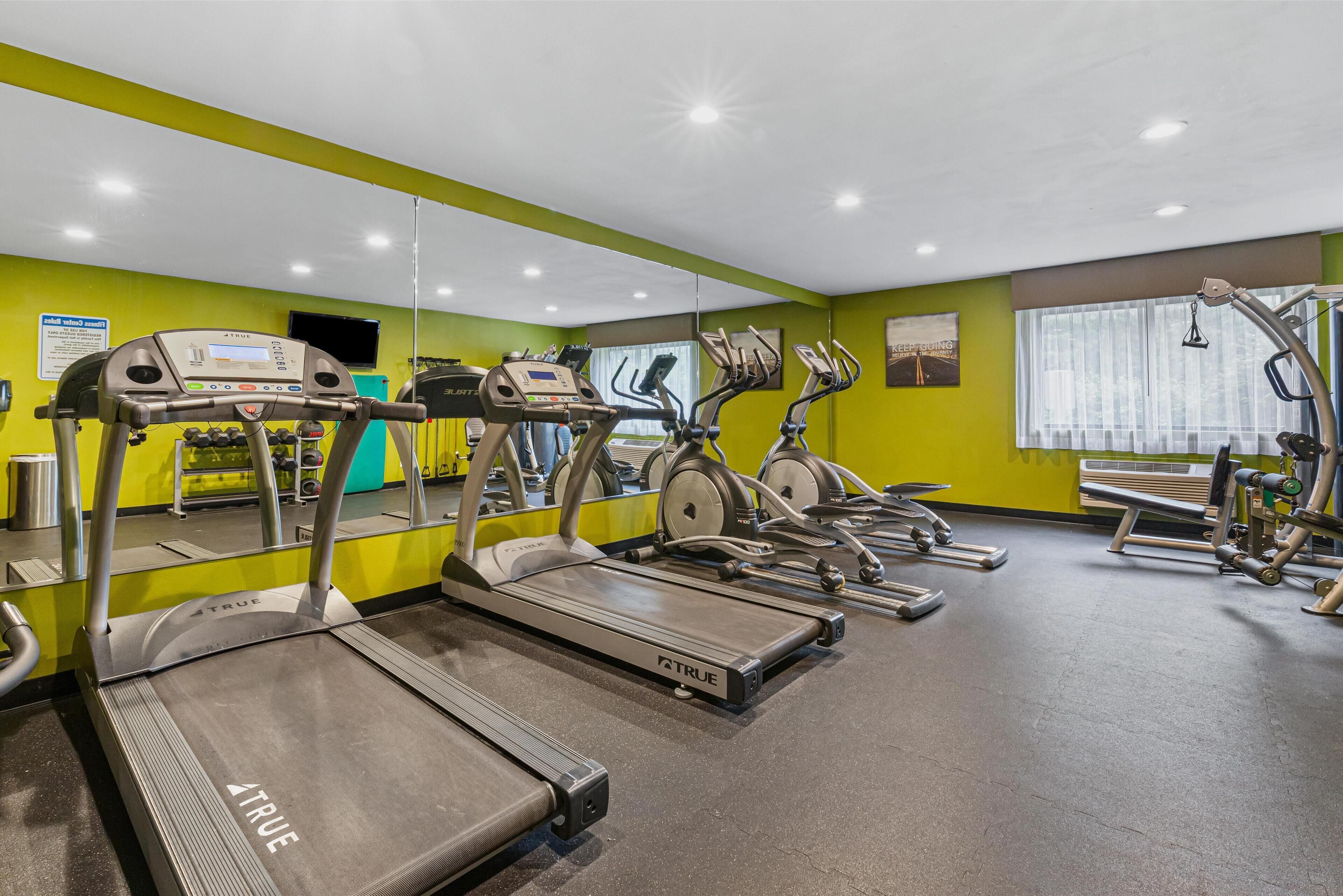 A gym with treadmills, ellipticals, and weight machines.
