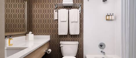 Ein modernes Badezimmer mit Toilette, Waschbecken und Badewanne.
