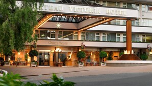 Hotel Chateau Victoria, con una entrada destacada, zona de estar al aire libre y una fuente central.