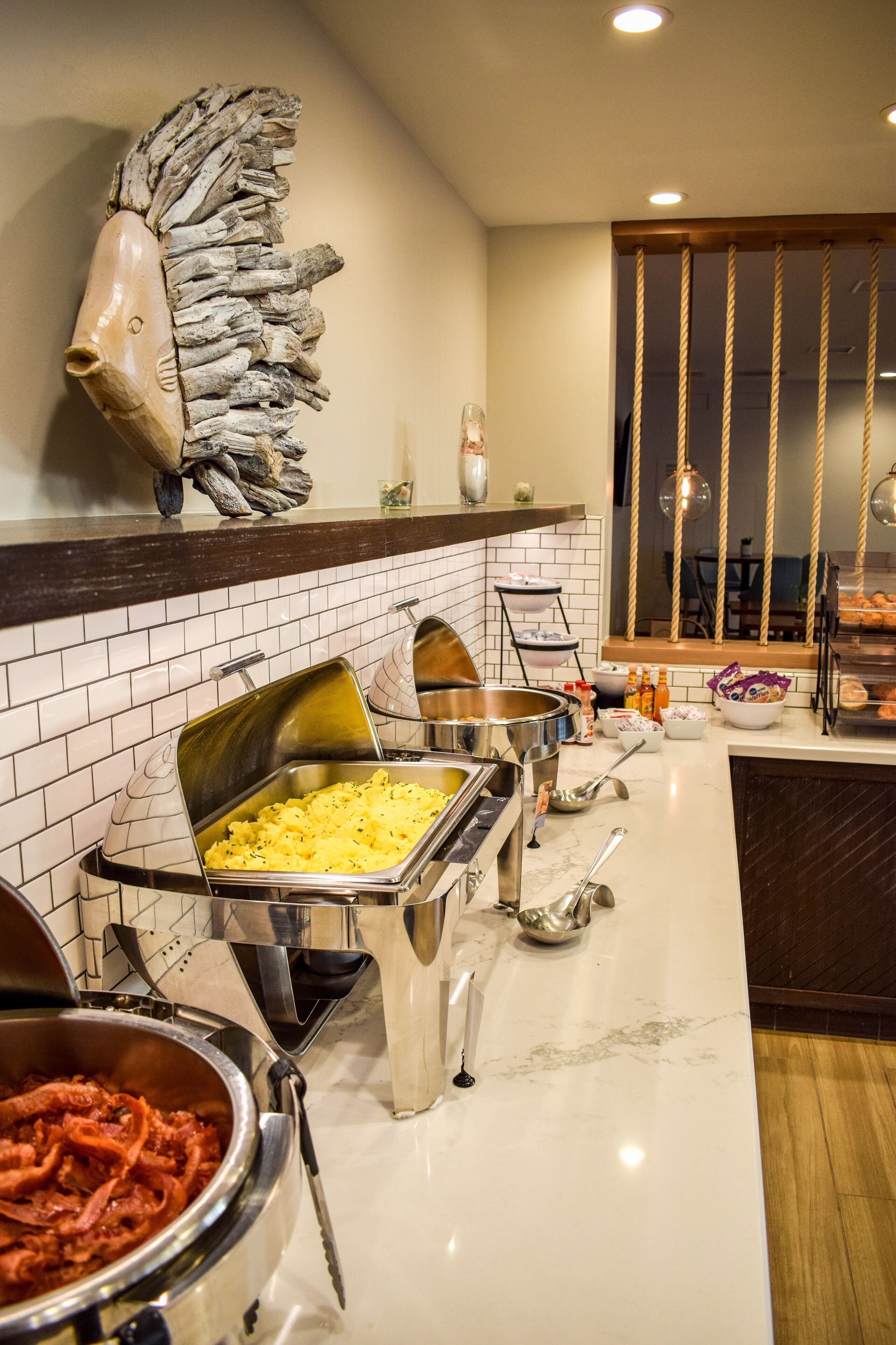 A buffet setup with various food items and serving utensils.