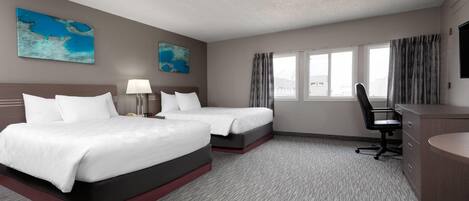 A hotel room with two beds, a desk, a chair, a TV, and two paintings.