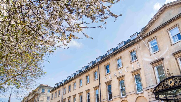 Un edificio histórico con el nombre "FRANCIS" en la fachada, que presenta arquitectura clásica con varias ventanas y una entrada destacada.