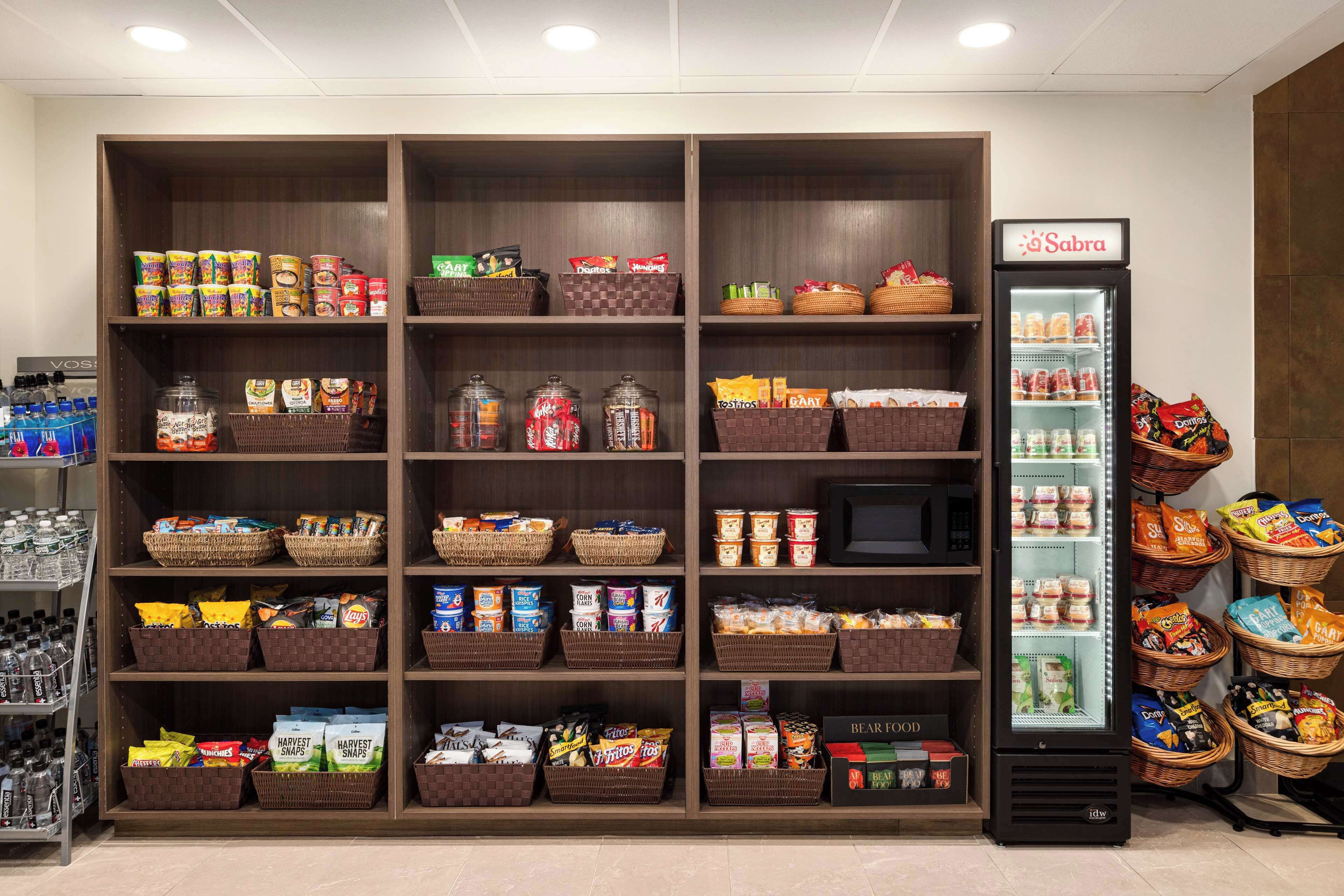 A well-organized snack and beverage display with various packaged goods and a refrigerated section.