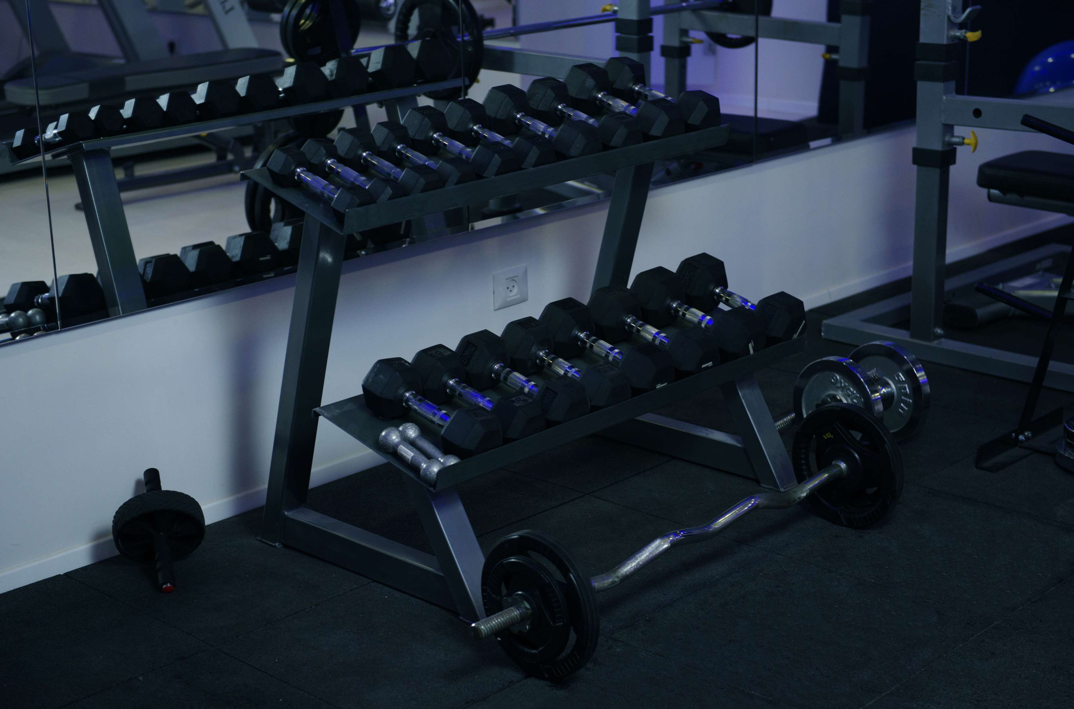A gym with a weight bench and dumbbells.