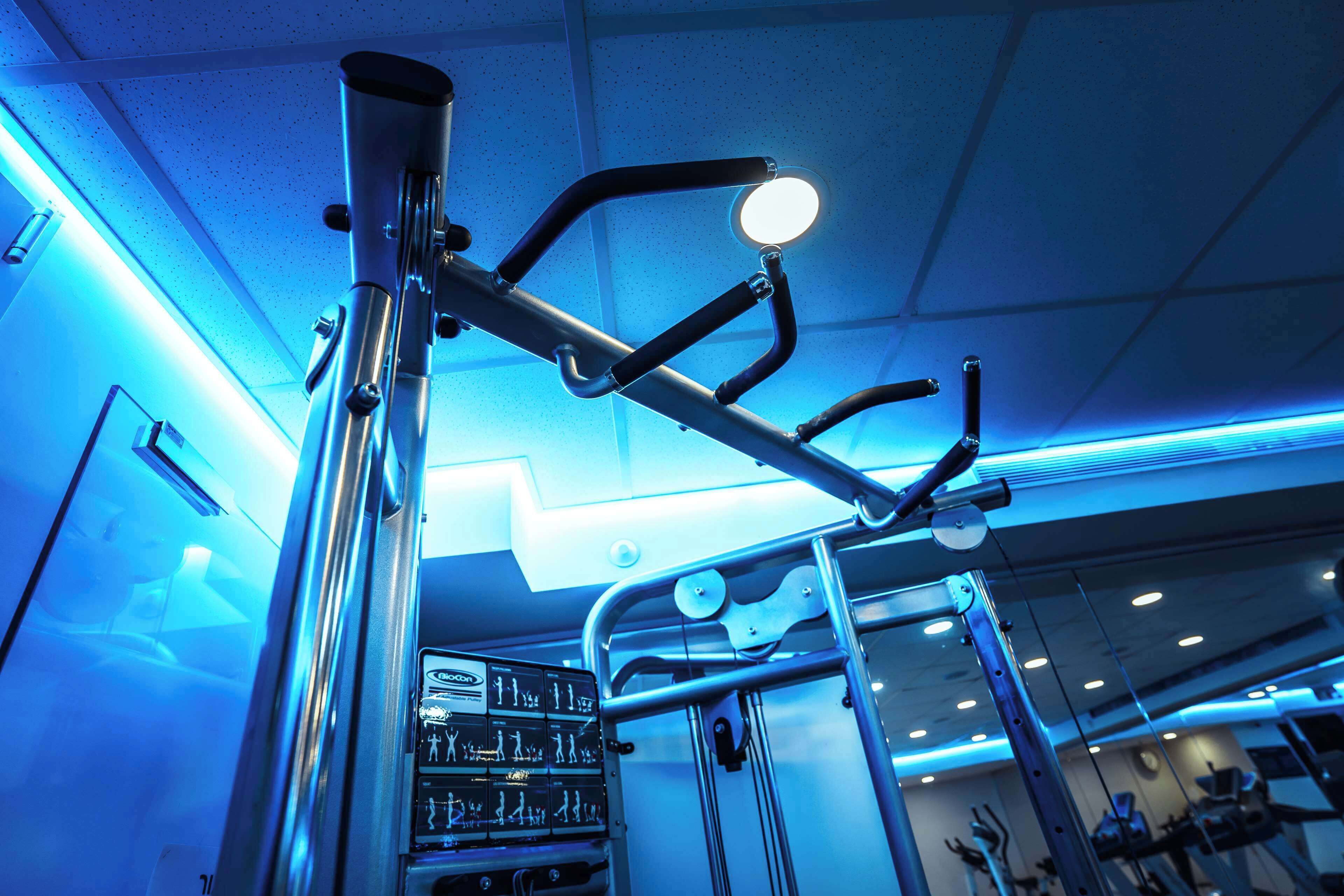 A gym with exercise equipment, a mirror, and a sign with workout instructions.
