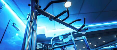 A gym with exercise equipment, a mirror, and a sign with workout instructions.