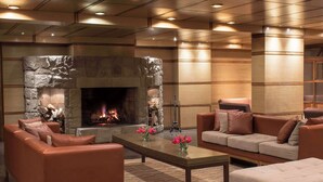Una sala de estar moderna con chimenea de piedra, sofás de cuero y una mesa de centro.