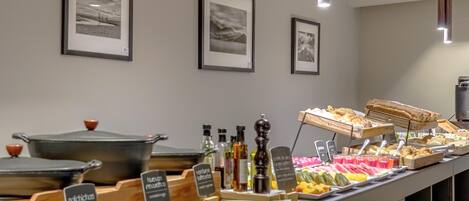 Een buffet met diverse gerechten en bijbehorende sauzen.