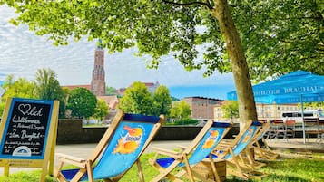 Terrasse extérieure avec un panneau indicateur et une vue sur une tour en arrière-plan.