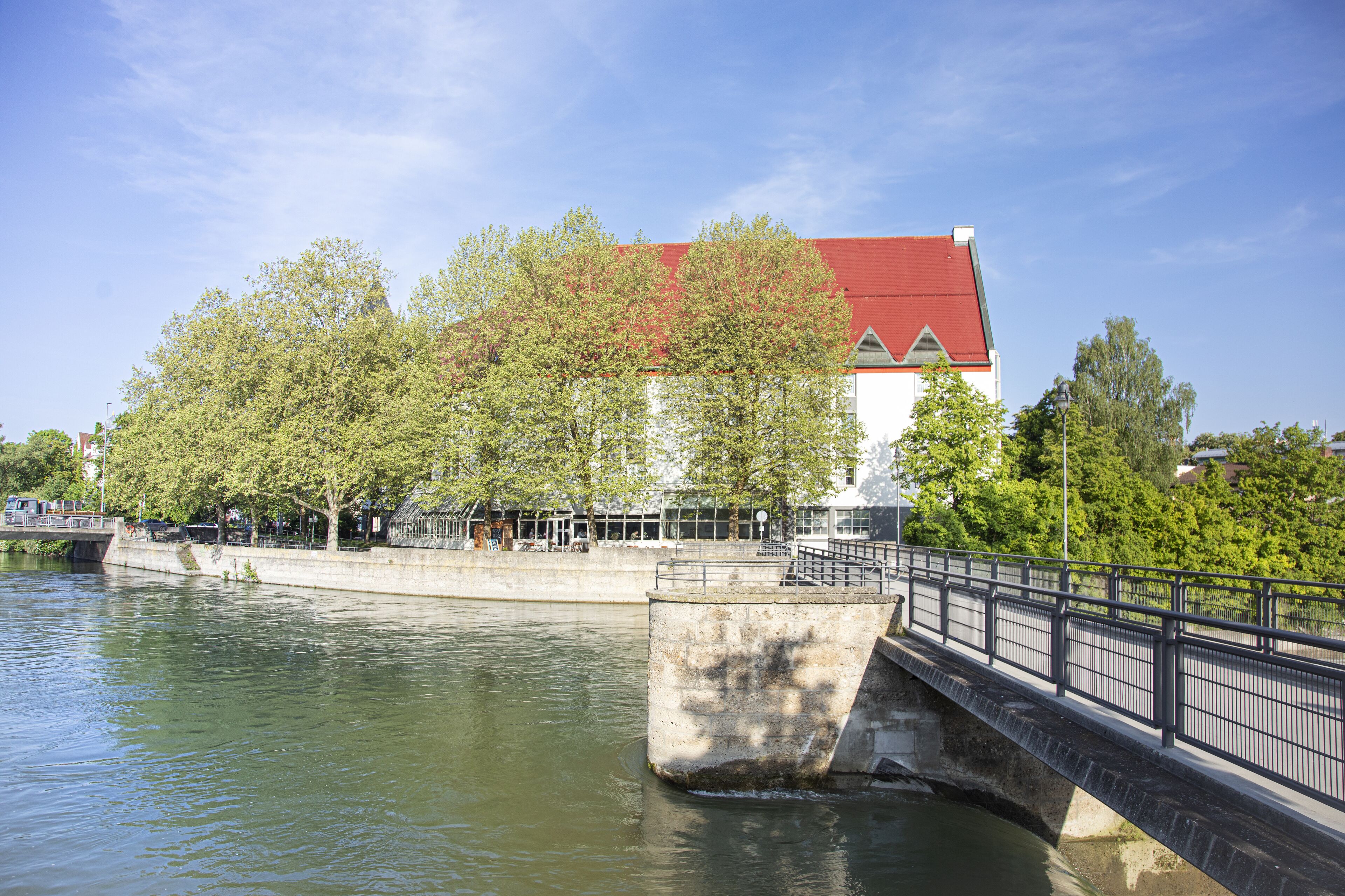 A bridge over a river with a building in the background.