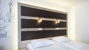 A bedroom with a wooden headboard, two bedside tables, and a bed with white bedding.