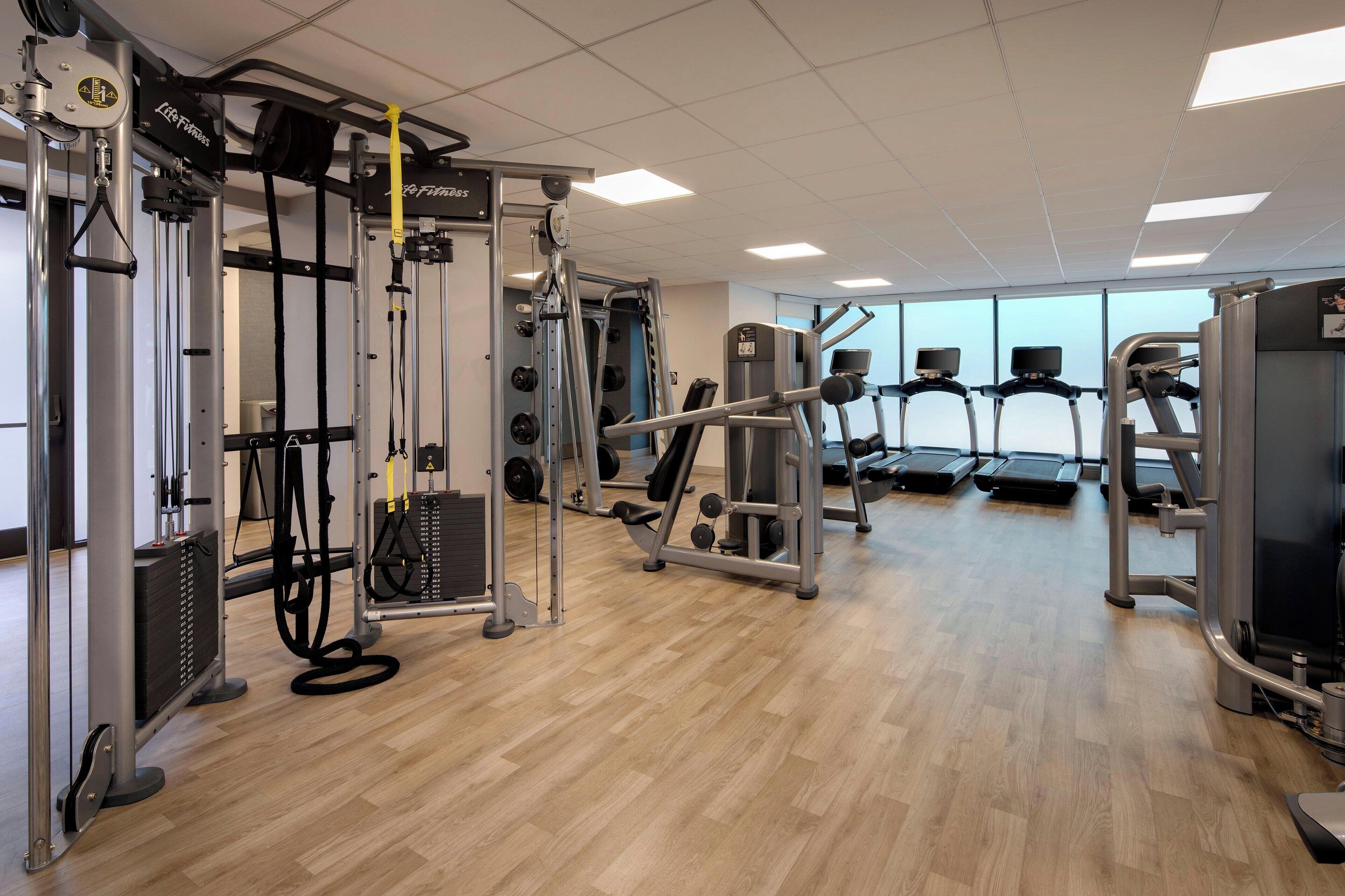 A gym with cardio equipment, weight machines, and free weights.
