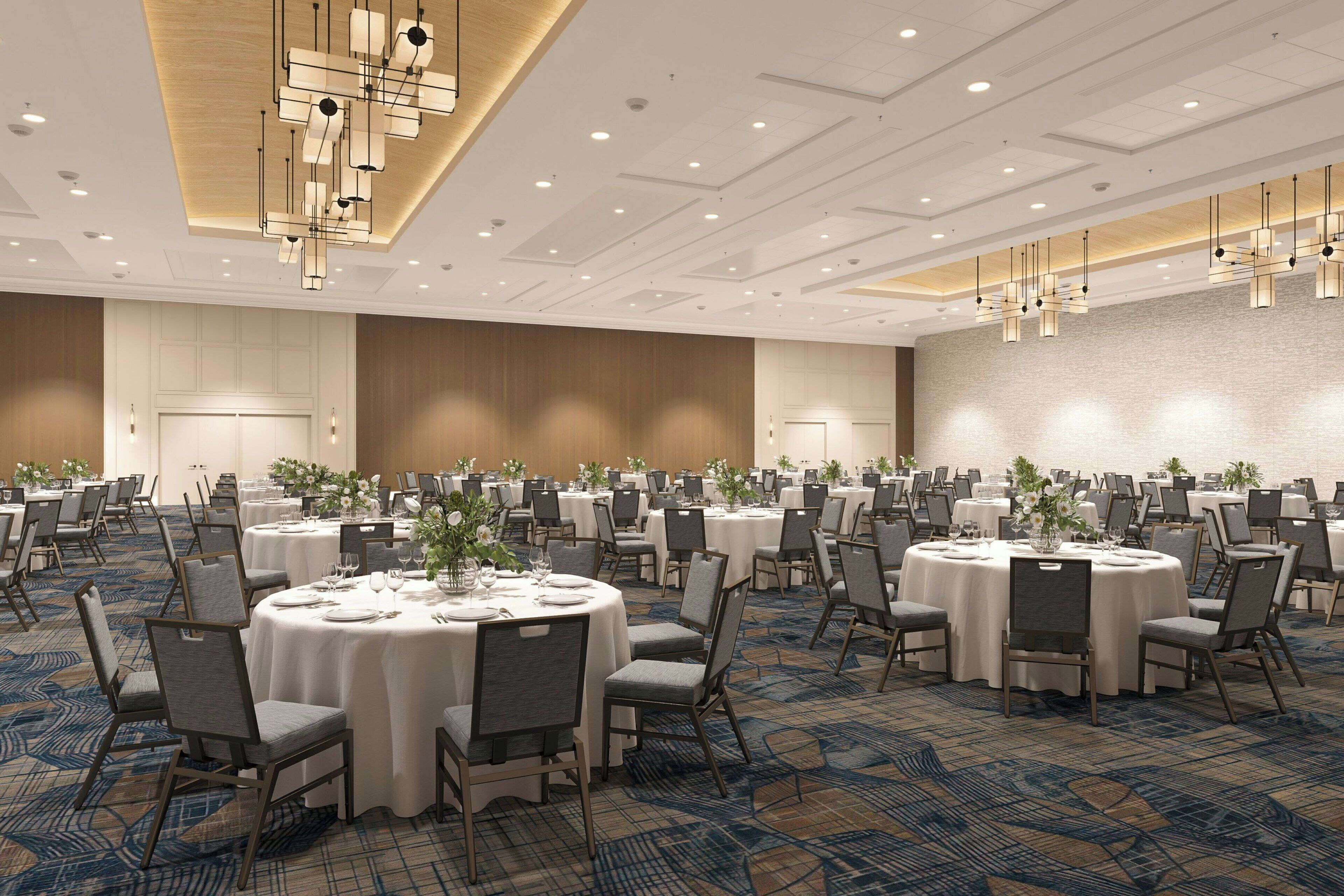 A conference room with round tables, chairs, and a patterned carpet.