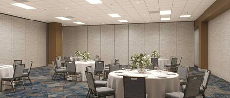 A conference room with round tables, chairs, and floral centerpieces.