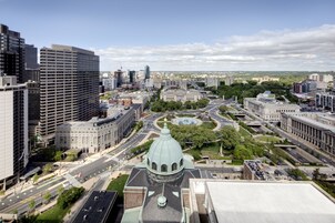 Un paisaje urbano con una cúpula destacada rodeada de edificios modernos y un parque bien cuidado.