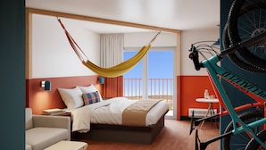 A hotel room with a bed, a hammock, a bicycle, and a balcony with a view. - LOGE St. George (St. George)