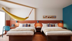 A hotel room with two beds, a desk, a chair, a hammock, and a wall with pictures. - LOGE St. George (St. George)
