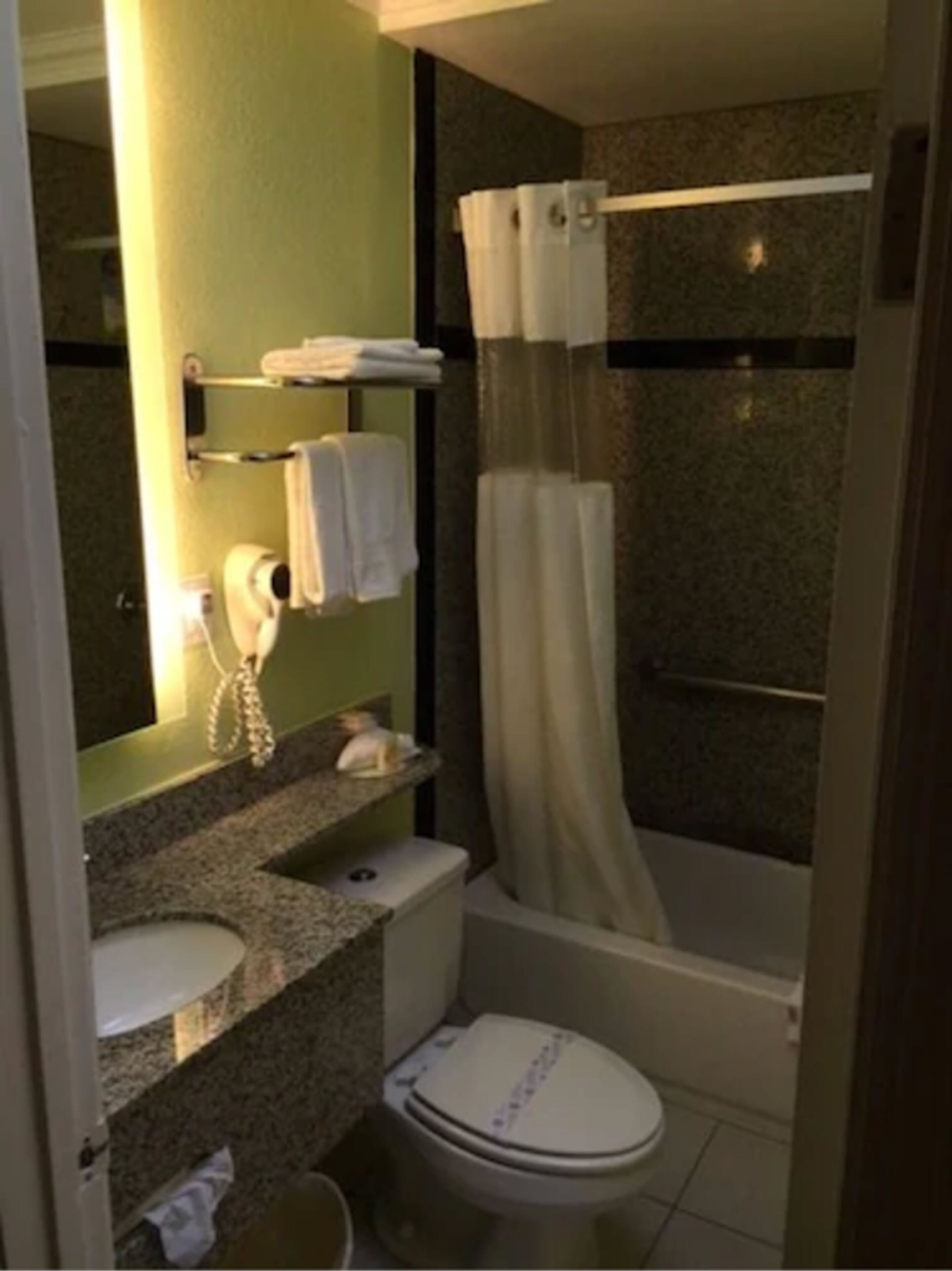 Et badeværelse med toilet, håndvask og bruser.