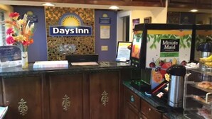 A reception area with a Days Inn sign, a coffee machine, and a menu board. - Days Inn by Wyndham San Francisco - Lombard (San Francisco)