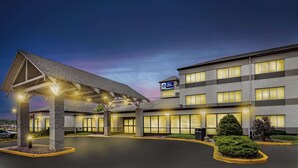 A hotel with a covered entrance, multiple floors, and a sign indicating it is a Best Western property.