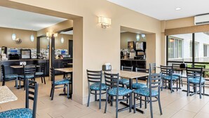 A hotel dining area with multiple tables and chairs, a coffee machine, and a counter with a menu.