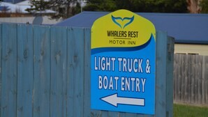 A sign for Whalers Rest Motor Inn indicating a light truck and boat entry.
