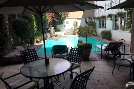 Una piscina al aire libre, sillones reclinables de piscina