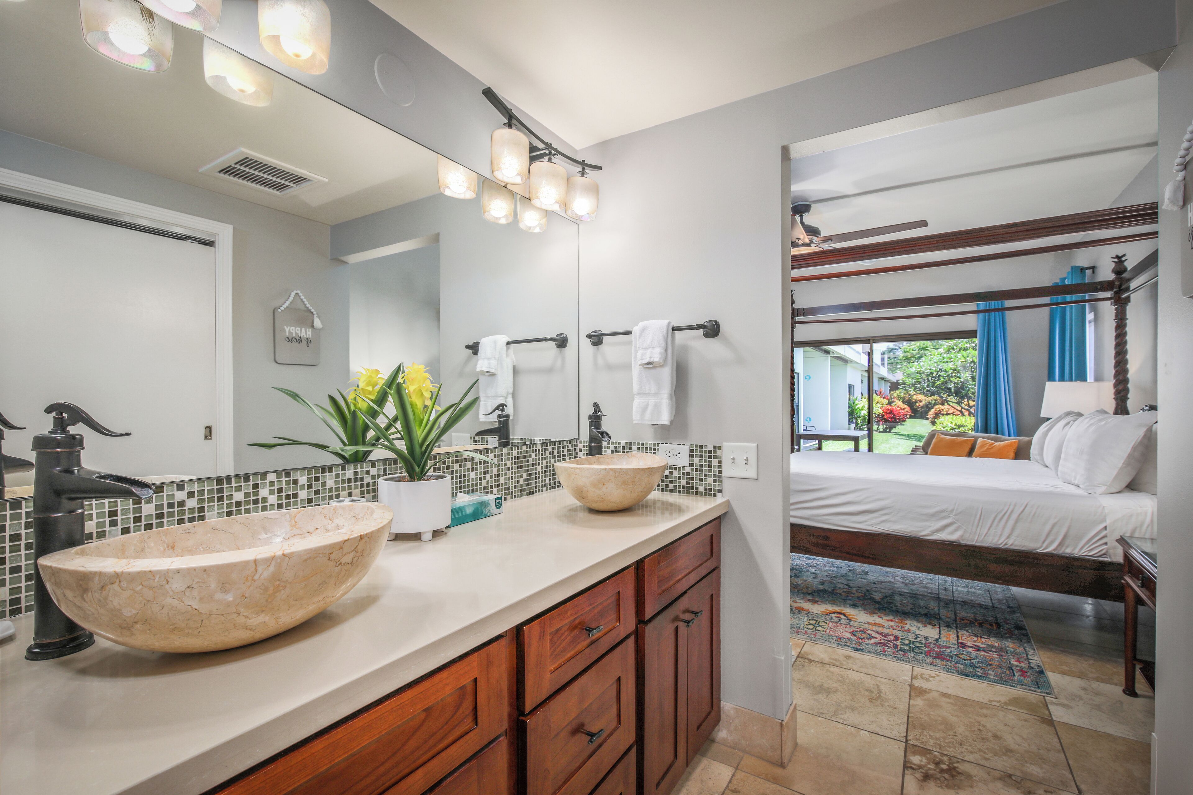 A bathroom with a large marble sink, wooden cabinets, and a mirror.