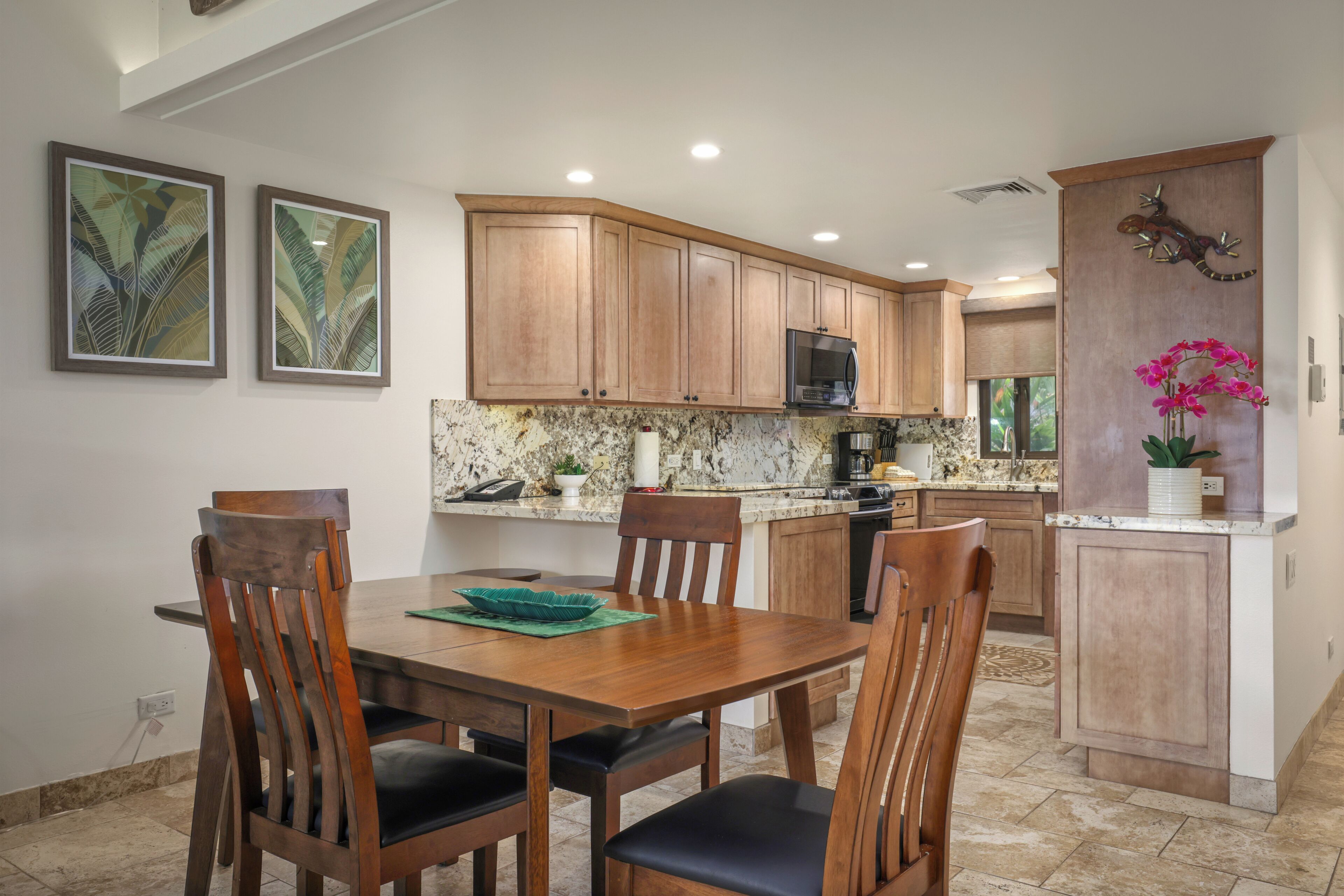 A kitchen with wooden cabinets, a dining table with chairs, and a microwave.