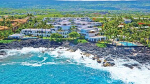 A coastal resort with multiple buildings, a rocky shoreline, and a clear view of the ocean.
