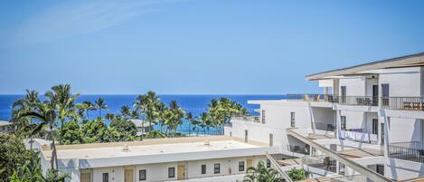 A multi-story hotel with balconies overlooking a beach and ocean.