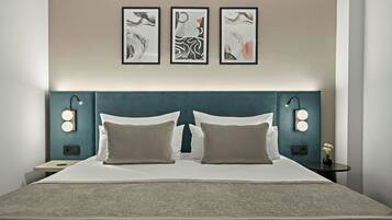 Ein Hotelzimmer mit einem großen Bett, zwei Nachttischlampen und drei gerahmten Kunstwerken an der Wand.