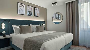 Ein modernes Hotelzimmer mit einem großen Bett, Nachttischlampen und Kunstwerken an den Wänden.