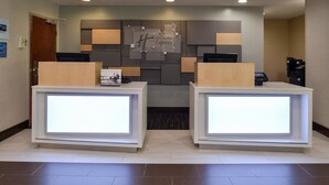 A reception area with two reception desks, a wall-mounted sign, and a door. - Holiday Inn Express Towson - Baltimore North by IHG (Towson)