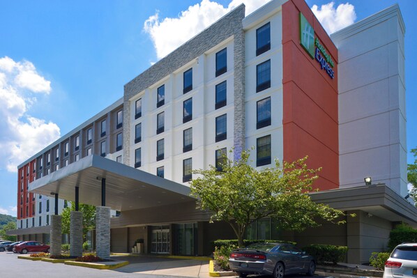 A multi-story Holiday Inn Express building with a flat roof, large windows, and a covered entrance area.