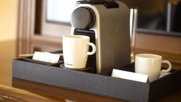 A coffee machine with two white cups on a tray.