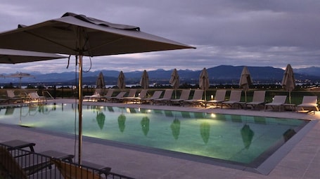 Una piscina al aire libre de temporada, sombrillas