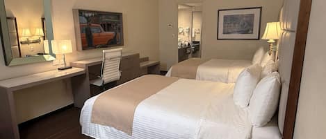 Una habitación de hotel con una cama, un escritorio, una silla, un espejo y un cuadro en la pared.