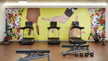 A gym with treadmills, elliptical machines, and free weights.
