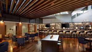 A modern bar area with a wooden ceiling, bar stools, and a central bar counter. - DoubleTree by Hilton Atlanta Perimeter Dunwoody (Atlanta)