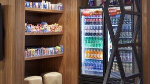 A corner vending area with a Coca-Cola refrigerator and shelves stocked with snacks and drinks. - DoubleTree by Hilton Atlanta Perimeter Dunwoody (Atlanta)