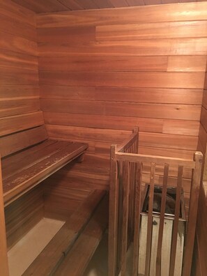 A wooden sauna with benches and a bench seat.