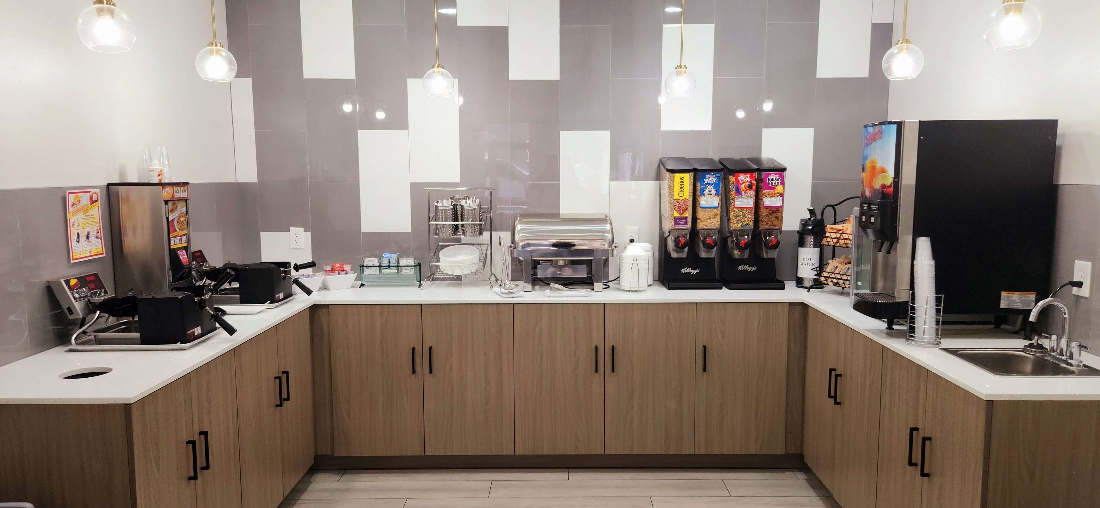 A modern kitchen with wooden cabinets, a coffee machine, a kettle, and a refrigerator.