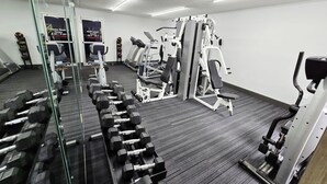 A gym with various exercise equipment, including dumbbells, treadmills, and weight machines.