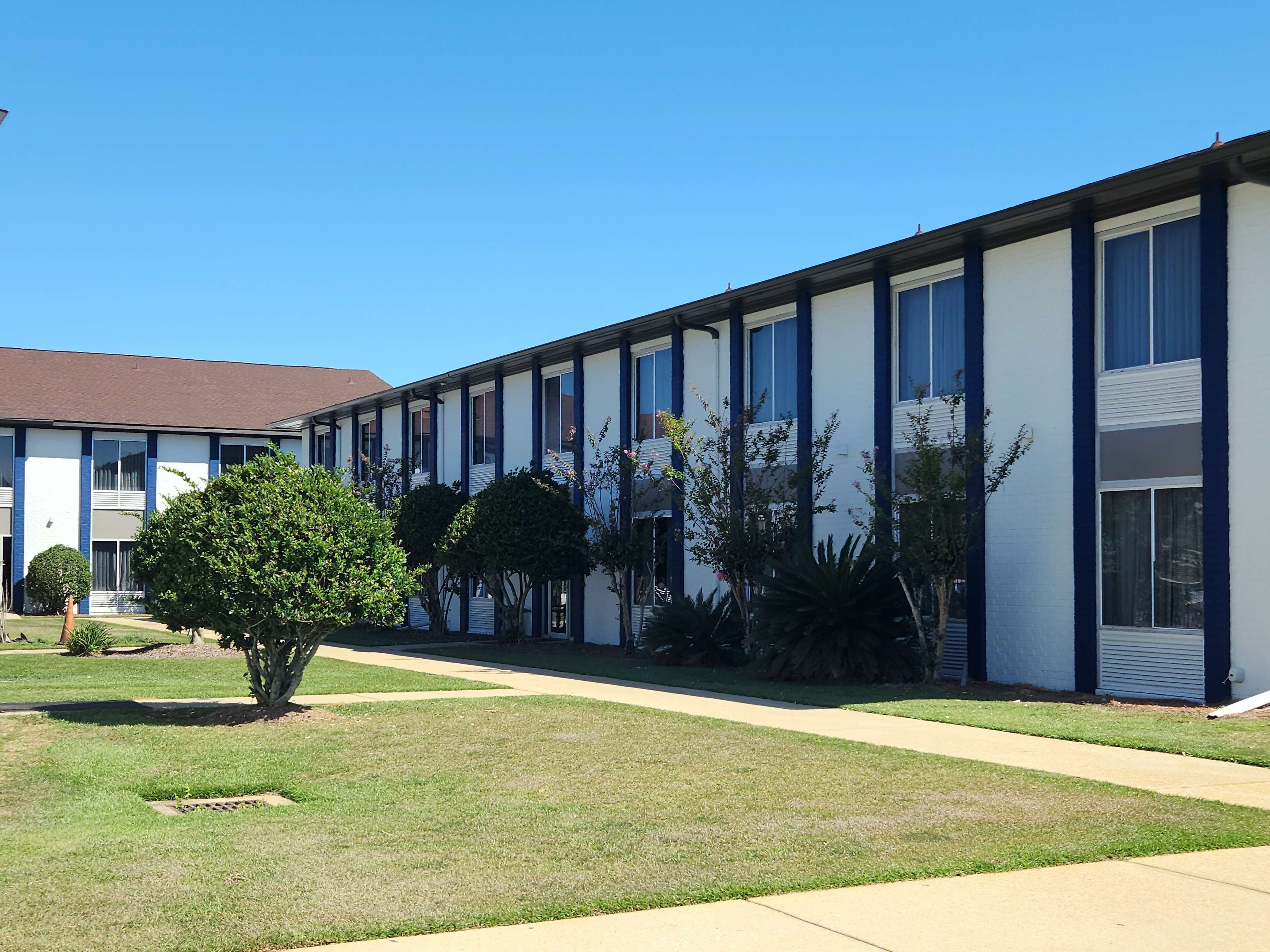 A row of single-story buildings with a consistent exterior design, featuring large windows and a flat roof.