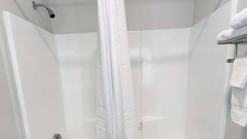 A white bathroom with a bathtub, a shower curtain, and a towel rack.